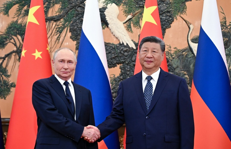 Sur cette photographie diffusée par l'agence d'État russe Sputnik, le président russe Vladimir Poutine serre la main du président chinois Xi Jinping lors d'une réunion au Grand Palais du Peuple à Pékin le 2 septembre 2025