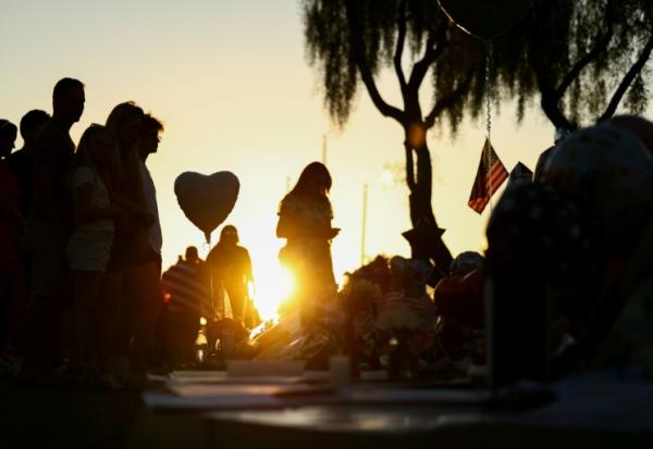 Des personnes se recueillent devant un mémorial improvisé en hommage à l'influenceur conservateur Charlie Kirk, le 14 septembre 2025 à Phoenix, en Arizona