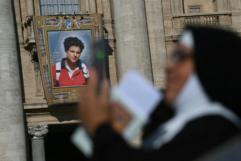 Un portrait de l'adolescent italien Carlo Acutis sur la façade de la basilique Saint-Pierre avant une messe de canonisation du bienheureux Carlo Acutis et de Pier Giorgio Frassati place Saint-Pierre, au Vatican, le 7 septembre 2025