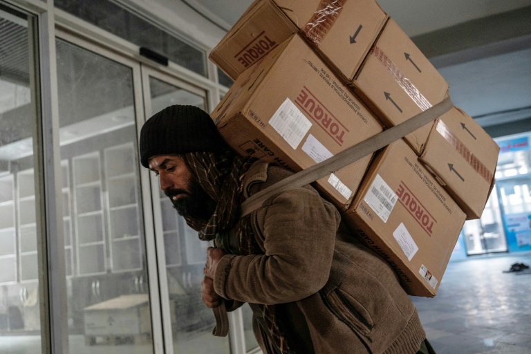 Un homme transporte des colis pharmaceutiques importés d'Inde dans une pharmacie à Kaboul, le 9 février 2026 en Afghanistan