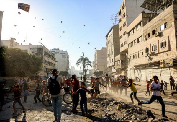 Des habitants de Gaza-ville assistent à un lâcher de tracts par l'armée israélienne appelant à l'évacuation de la ville, le 9 septembre 2025