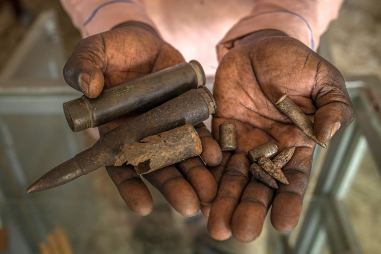 Un homme montre des balles exposées au Mémorial de Lukodi, souvenir du'un massacre perpétré dans ce village du nord de l'Ouganda en mai 2004 par la guérilla ougandaise de l'Armée de résistance du Seigneur (LRA), le 4 septembre 2025