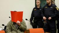 L'Afghan Farhad N. (g.), le visage caché derrière un dossier, est assis dans la salle d'audience du tribunal, le 16 janvier 2026 à Munich, pour le début de son procès pour avoir foncé en voiture dans la foule à Munich en 2025