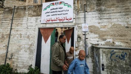 Les jumeaux Ahmad (d) et Mohammad, accompagnés par leur père Ibrahim al-Hajj, sortent de leur école à Naplouse, le 10 février 2026 en Cisjordanie occupée