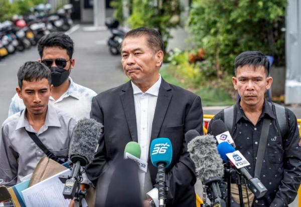 L'avocat Kunpat Singhathong (c) s'adresse aux médias aux côtés de trois anciens marins du cargo battant pavillon thaïlandais *Mayuree Naree*, devant le Tribunal central du travail à Bangkok, le 10 juillet 2026 en Thaïlande