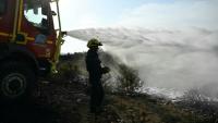 Des pompiers éteignent des cendres chaudes à côté d'Albas, dans le massif des Corbières, le 9 août 2025