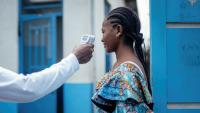 Un membre du personnel de l'hôpital CBCA Virunga prend la température d'une visiteuse à l'aide d'un thermomètre infrarouge sans contact avant de l'autoriser à entrer dans l'hôpital de Goma, en République démocratique du Congo, le 17 mai 2026. 
