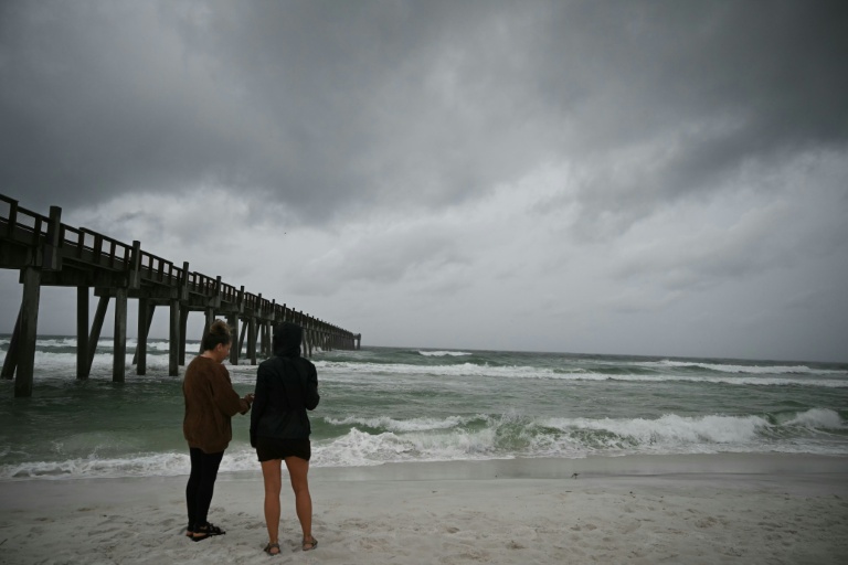 Des personnes observent les vagues à l'approche de l'arrivée de l'ouragan Isaias à Pensacola Beach, en Floride aux Etats-Unis, le 9 octobre 2026