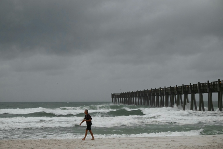 Une personne observe les vagues à l'approche de l'arrivée de l'ouragan Isaias à Pensacola Beach, en Floride aux Etats-Unis, le 9 octobre 2026