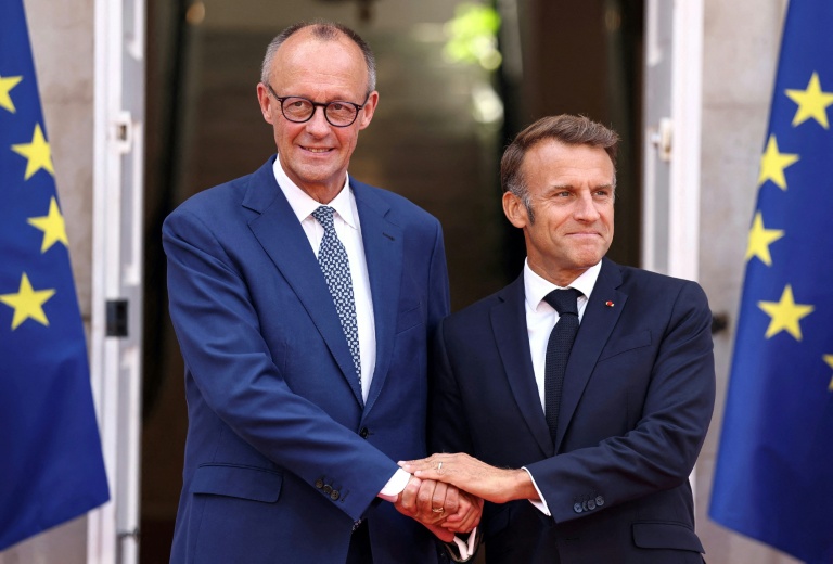 Le président français Emmanuel Macron (d) et le chancelier allemand Friedrich Merz se serrent la main avant une réunion à Toulon, dans le sud-est de la France, le 29 août 2025