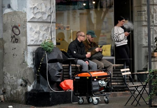 Un générateur en marche devant un café à Kiev durant une coupure de courant causée par des frappes russes sur des installations électriques, le 18 octobre 2026