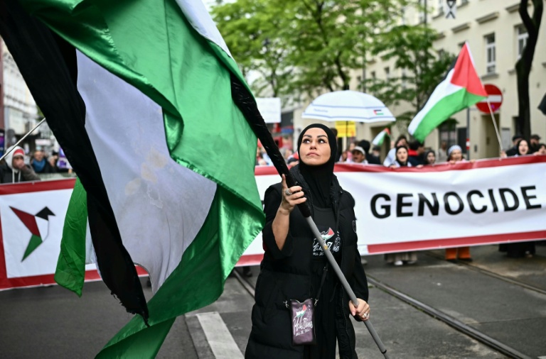 Une femme portant un drapeau palestinien lors d'une manifestation à Vienne, en Autriche, le 16 mai 2026.