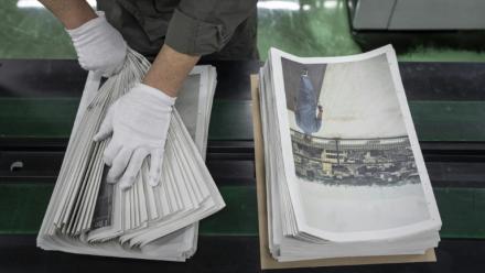 Un employé emballe l'œuvre du photographe Kazuma Obara, "The Newspaper", à Kumiyama, dans la préfecture de Kyoto, au Japon, le 19 mars 2026