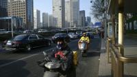 Des livreurs de repas conduisent des scooters électriques à Pékin, le 16 janvier 2024