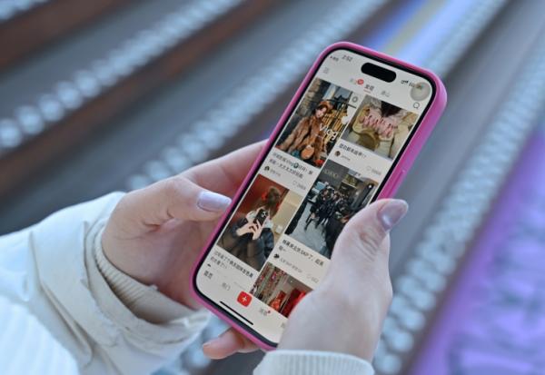 Une femme consulte sur son smartphone le réseau social chinois Xiaohongshu, également connu sous le nom de RedNote, le 15 janvier 2025 à Pékin