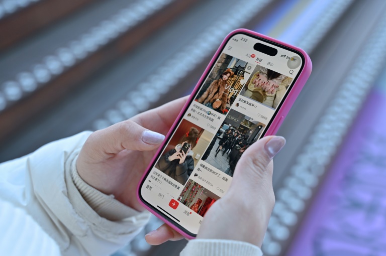 Une femme consulte sur son smartphone le réseau social chinois Xiaohongshu, également connu sous le nom de RedNote, le 15 janvier 2025 à Pékin