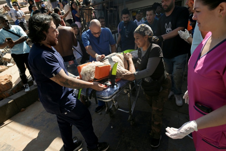 Une femme sortie des décombres est transportée par les secouristes sur un brancard, après un puissant tremblement de terre, à Cali en Colombie le 10 août 2026