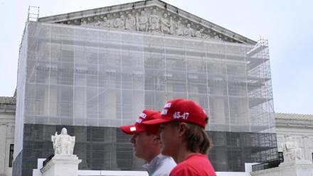 Deux hommes portant des casquettes "Make America Great Again" (MAGA, Rendre sa grandeur à l'Amérique), passent devant la Cour suprême des Etats-Unis, à Washington, le 27 juin 2025