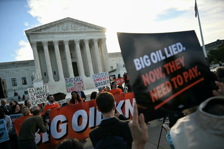 Des personnes manifestent pour dénoncer la contribution des compagnies pétrolières au changement climatique devant la Cour suprême des Etats-Unis, à Washington le 5 octobre 2026