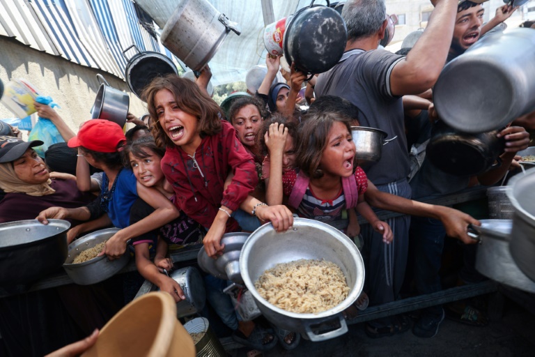 Des enfants palestiniens se bousculent pour recevoir un repas chaud à Nousseirat, dans la bande de Gaza, le 4 septembre 2025