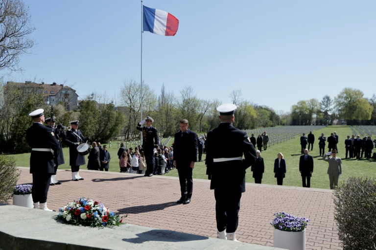 Le président français Emmanuel Macron (c) dépose une gerbe de leurs au cimetière militaire français de Gdansk, lors d'une visite en Pologne, le 20 avril 2026