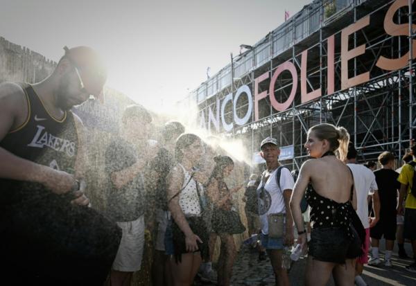 Des festivaliers se rafraîchissent à l'aide de brumisateurs aux Francofolies de La Rochelle, le 11 juillet 2026