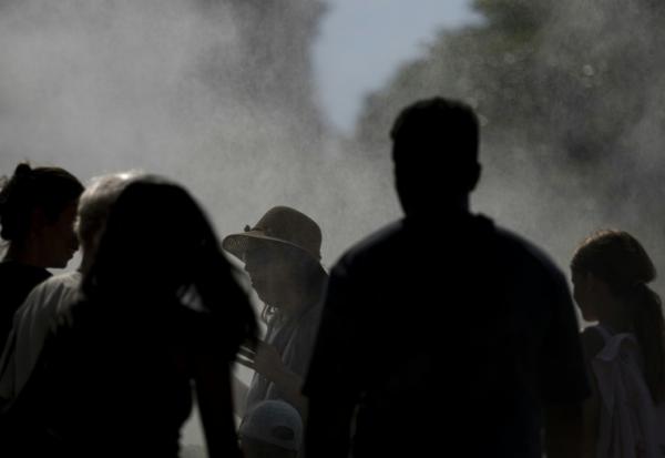 Des personnes sous un système de rafraichissement pendant la canicule à Strasbourg, le 20 juin 2026