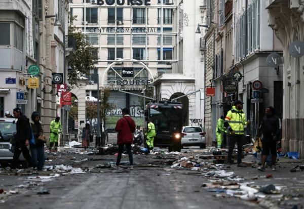 Des employés municipaux nettoient une rue jonchée de débris au lendemain d'une manifestation contre la vie chère, le 18 octobre 2026 à Marseille