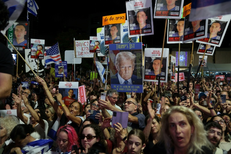 Des personnes brandissent des drapeaux israéliens et américains lors d'un rassemblement sur la place des Otages à Tel-Aviv, le 11 octobre 2025