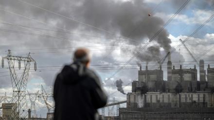 Un homme observe la fumée noire s'échappant de la centrale électrique au charbon d'Afsin-Elbistan, dans la province d'Elbistan, le 11 février 2026 en Turquie
