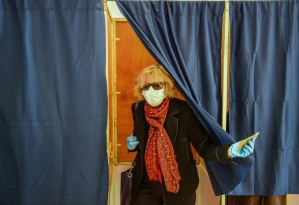 Une femme portant un masque sort d'un isoloir lors du premier tour des élections municipales, le 15 mars 2020 à Bordeaux