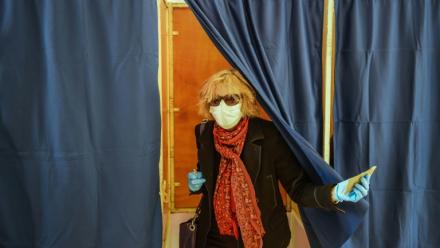 Une femme portant un masque sort d'un isoloir lors du premier tour des élections municipales, le 15 mars 2020 à Bordeaux