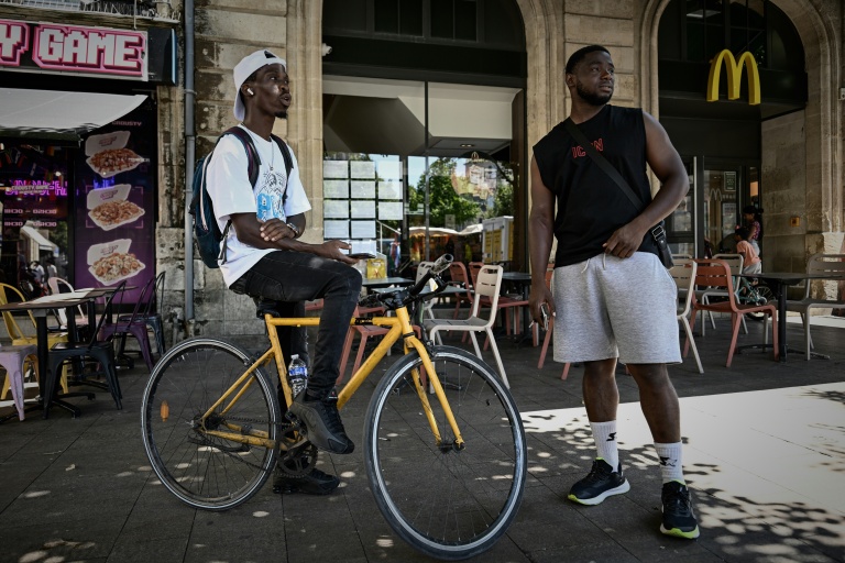 Deux livreurs à vélo se reposent pendant une vague de chaleur estivale près des restaurants en attendant des commandes, à Bordeaux, le 7 juillet 2026