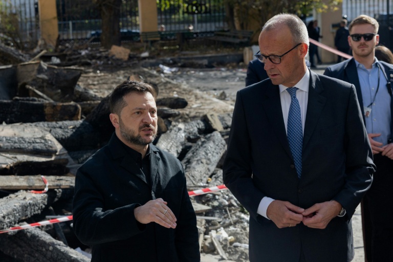 Le président ukrainien Volodymyr Zelensky (G) et le chancelier allemand Friedrich Merz (D) lors d'une visite du bâtiment endommagé de l'Académie des sciences de Kiev, le 4 octobre 2026 