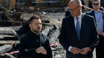 Le président ukrainien Volodymyr Zelensky (G) et le chancelier allemand Friedrich Merz (D) lors d'une visite du bâtiment endommagé de l'Académie des sciences de Kiev, le 4 octobre 2026 