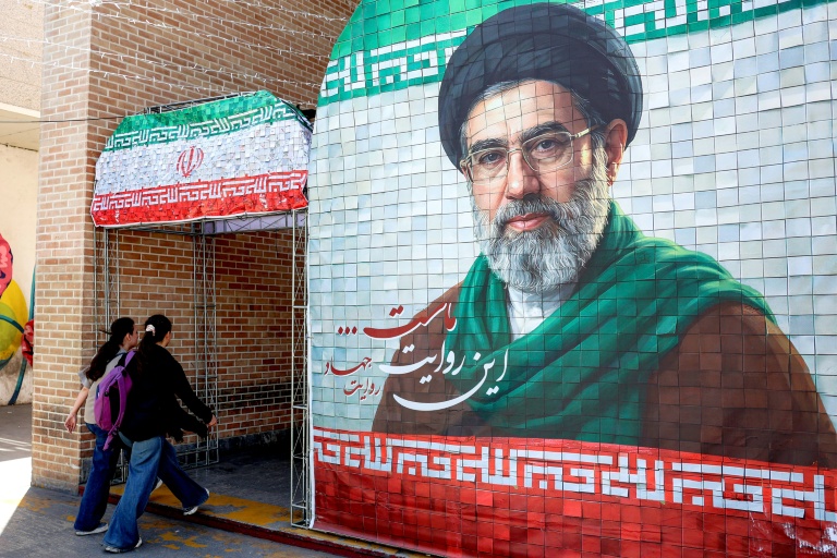 Des Iraniennes passent devant un portrait du nouveau guide suprême iranien, le 6 mai 2026 à Téhéran
