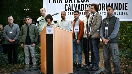 (g-d) Le journaliste de guerre américain Jon Lee Anderson, les collaborateurs de l'AFP Belal Al-Sabbagh, Mohannad Shahwan, Mai Yaghi, Adel Zaanoun, Said Khatib, Mohammed Abed, le directeur général de RSF Thibault Bruttin et le collaborateur de l'AFP Mahmud Hams rendent hommage aux journalistes morts à la guerre devant le mémorial 2024-2025 en hommage aux journalistes décédés au cours de l'année écoulée, à l'occasion du "Prix Bayeux Calvados-Normandie des correspondants de guerre", le 9 octobre 2025 dans le Calvados