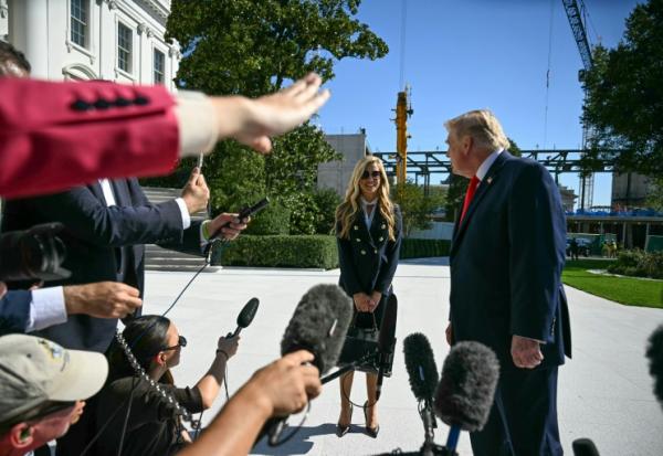 Le président américain Donald Trump se tourne vers la nouvelle porte-parole de la Maison Blanche, Kate Zacharia, devant la presse à Washington le 13 octobre 2026