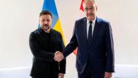 Le président suisse Guy Parmelin (d.) serre la main du président ukrainien Volodymyr Zelensky avant une rencontre bilatérale en marge du sommet du G7, à l'aéroport de Genève, le 15 juin 2026
