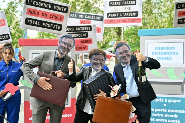 Des personnes portant un masque à l'effigie du Pdg de TotalEnergies Patrick Pouyanné manifestent à Paris à l'appel d'ONG écologistes à l'occasion de la publication des résultats du géant français pétrogazier, le 29 avril 2026
