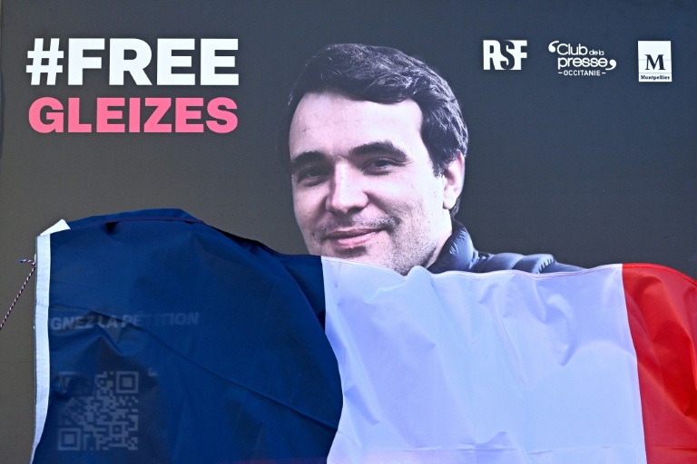 Un portrait du journaliste français Christophe Gleizes, détenu en Algérie, est dévoilé lors d'une manifestation organisée pour réclamer sa libération, à Montpellier, dans le sud de la France, le 29 janvier 2026