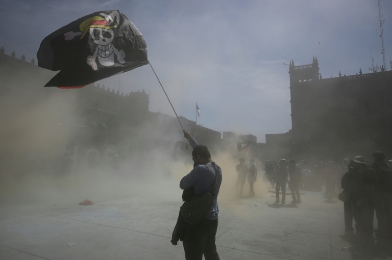 Un homme brandit le drapeau du manga One Piece lors d'une manifestation antigouvernementale à Mexico le 15 novembre 2025
