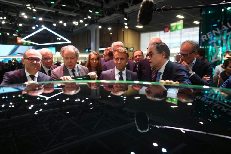 Emmanuel Macron, entouré de Luc Chatel, président de la Plateforme automobile (à gauche), et de François Provost, directeur général du groupe Renault, au Mondial de l’Auto à Paris, le 12 octobre 2026
