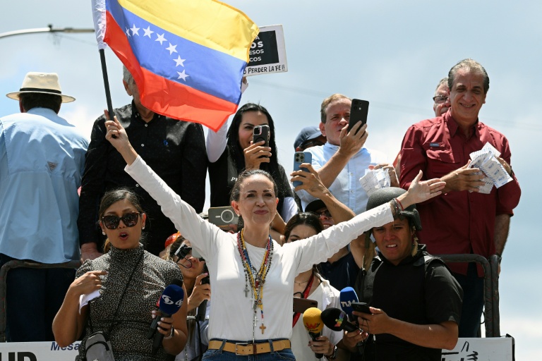 Maria Corina Machado (centre) brandit un drapeau vénézuélien lors d'une manifestation de l'opposition à Caracas le 17 août 2024