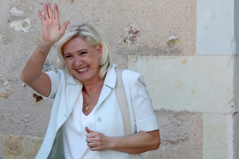 Marine Le Pen, cheffe du groupe parlementaire Rassemblement national (RN) et candidate à la présidentielle de 2027, salue ses sympathisants après une réunion de campagne à l'hôtel de ville de La Flèche, le 8 juillet 2026 dans la Sarthe