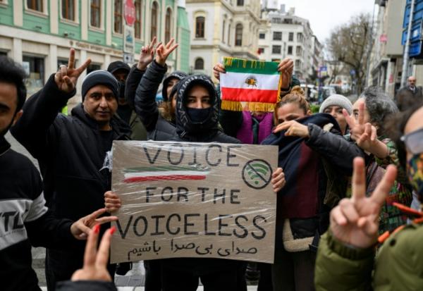 Des manifestants opposés au régime iranien brandissent une pancarte et le drapeau iranien d'avant la révolution de 1979, lors d'une manifestation devant le consulat iranien à Istanbul, le 11 janvier 2026