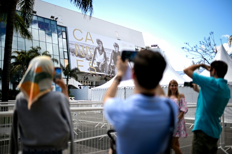 Des passants photographient la façade du Palais du festival à Cannes le 11 mai 2026