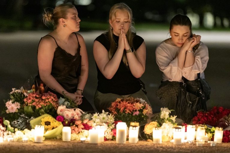 Des personnes offrent des prières lors d'une veillée nocturne pour le roi Harald V de Norvège sur la place du Palais à Oslo, tôt le 28 août 2026.