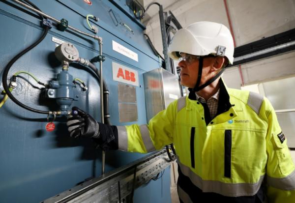 Guy Nicholson, responsable des solutions réseau neutres en carbone chez Statkraft, se tient près d'un volant d'inertie, le 7 août 2025 à Liverpool