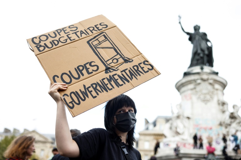Une manifestante tient une pancarte sur laquelle on peut lire 